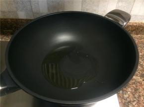 热锅倒油烧至八成热。
