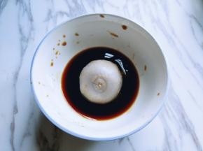 将蒸熟的芋头放入酱汁中，蘸满酱汁。