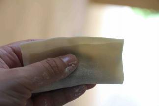 包裹馄饨：入15克以内馅，馅在中心向下位置呈长条形， 梯形馄饨皮短边上面沾水，馅在上，短边盖上入，未及长边1厘米处摁下使二片皮贴合，包四角元宝。