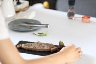 摆盘将学厨的石板均匀的抹上油，将牛排摆放在石板上，放上迷迭香或者紫苏，装饰完成作品。