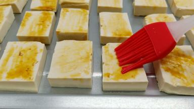 切片的豆腐依次码在烤盘上，刷一层加拿大芥花油，油味道清淡，适合烧烤，再刷一层生抽。