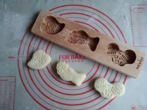 倒扣模具，轻敲出巧果坯，移至不粘烤盘上