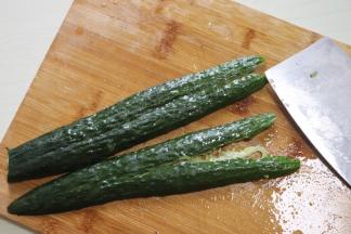 黄瓜一根对半切开，用刀面拍扁，然后斜切