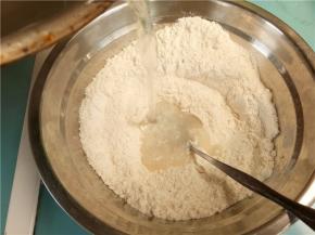 将烧开的沸水倒入面粉中，边倒边搅。接着在放入凉水。