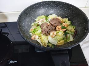 再加入将牛肉，炒好的虾仁，快速翻炒2分钟即可出锅。