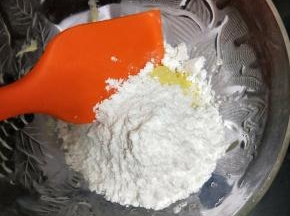 把所有糖粉倒入黄油里，先用硅胶铲翻拌一下，要不然打的时候糖粉会到处飞。