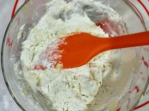 然后筛入低筋面粉，先用硅胶铲翻拌均匀，再用手揉成团。