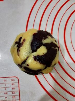 接着把两种颜色的面团放到一起，先用手抓住两种面团扯断几次，再稍微揉一下。