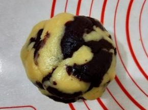 接着把两种颜色的面团放到一起，先用手抓住两种面团扯断几次，再稍微揉一下。