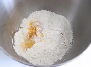 在厨师机桶中，加入南瓜泥，水，盐，糖，面粉，最后撒上干酵母。开启程序，并根据面团状态，是否加入预留的水，直到搅打成光滑的面团。