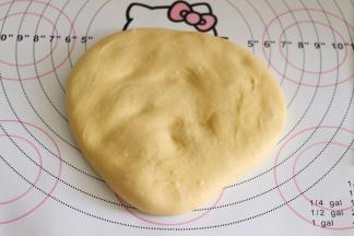 取出面团，来进行排气， 要温柔的轻轻的拍面团就可以了，不可以过度的揉面。