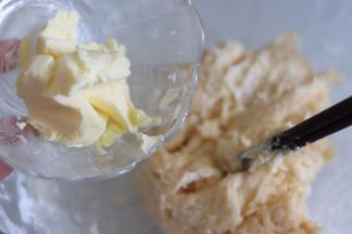 加入软化的黄油，尽量把黄油叠到面团里，用手辅助黄油融入。新手这步最好不要带手套，可以直接用手去感受判断面团的状态。