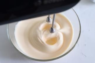 打发到蛋液有温度大约近40度，取出打蛋盆，继续搅打。