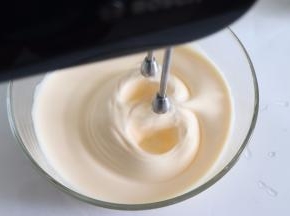 打发到蛋液有温度大约近40度，取出打蛋盆，继续搅打。