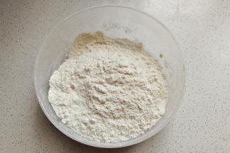 先称好低筋面粉，然后加入奶粉和泡打粉混合过筛待用。