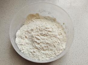 先称好低筋面粉，然后加入奶粉和泡打粉混合过筛待用。