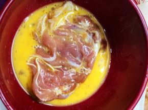 将腌制好的鸡腿放入鸡蛋液中，让两面都沾上蛋液。