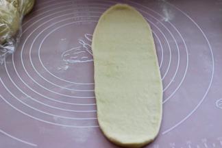 取一个醒发好的面团，用擀面杖擀成长舌状