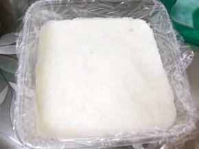 保鲜盒里铺上保鲜膜，把山药泥分成三份，取一份山药泥铺平