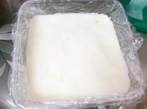 保鲜盒里铺上保鲜膜，把山药泥分成三份，取一份山药泥铺平