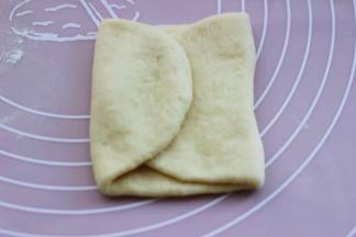 再把擀好的面皮，左右两边像中间对折一下