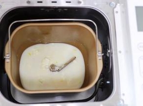 把奶粉、砂糖、全蛋液和牛奶倒入面包桶里
