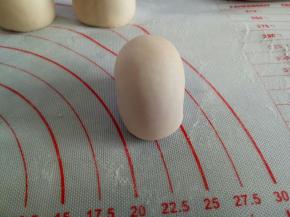 20克的面团作为头部，收口向下滚圆后捏扁一点