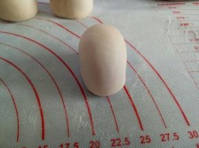 20克的面团作为头部，收口向下滚圆后捏扁一点