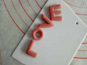 红色面团擀厚点的面片，用刮板切出LOVE的字母来，大小照着猪猪的身体来