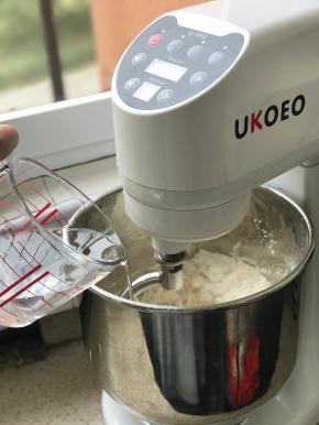 准备香蕉，放入保鲜袋里，用手揉捏袋子，揉成泥，放入厨师机出，除了黄油以外都放入厨师机中，开动机器揉面，因为做的量比较大，放水一定要预留，每个面粉品牌不同吸水度也不同，根据情况酌情添加，基本上还剩一点点干粉没有揉进去的时候就不要加水