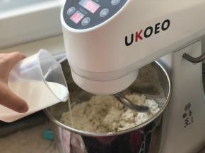 开2档，慢慢加入牛奶，根据面团情况加水，不要一次倒入，预留几克，我的面团加了140克