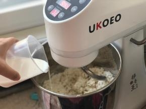开2档，慢慢加入牛奶，根据面团情况加水，不要一次倒入，预留几克，我的面团加了140克