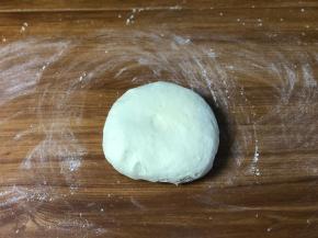 面团揉至光滑后，开始发酵，发至两倍大，取出揉面排气，醒面15分钟，分成2个面团揉圆按扁