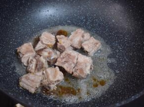 放入排骨，翻炒至上糖色