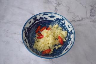 把蒜末和辣椒放入碗中，喜欢吃辣的话可以再加入小米椒，