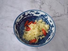 把蒜末和辣椒放入碗中，喜欢吃辣的话可以再加入小米椒，