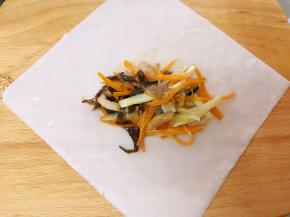 取一张春卷皮，摆入适量馅料