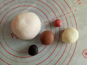 分别取15克揉入可可粉，10克揉入竹炭粉，5克揉入红曲粉，160克揉一点点红曲粉，剩下的白面团备用