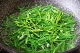 锅里倒入适量清水煮沸后、加入3克盐和几滴食用油、再把切好的芸豆丝焯水