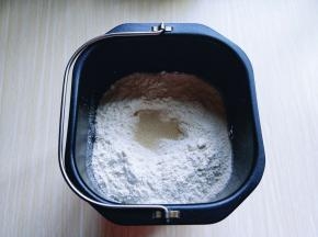 除黄油外的食材全部加入面包桶，先倒入牛奶，盐和糖对角放，草鸡蛋2个，奶粉，再加入高筋面粉，最后再面粉的顶端挖个洞，把酵母粉加入洞洞里，再用周边的面粉盖起来。