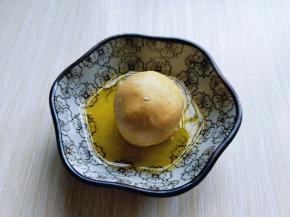 首先将面团搓成长条，再用刀切出大小等份的小面团，取一小块面团，包上豆沙馅揉圆，再放入融化的黄油碗中。（裹上黄油1、这样是为了更容易的沾满芝麻，2、特别香）