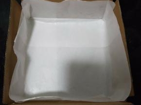 做蛋糕之前先把模具垫上油纸，四周边上各插一个硬纸板，不懂的请看图片