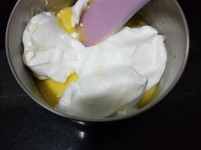 取3分之1的蛋白霜至蛋黄糊中混合均匀