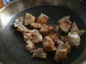 放入排骨快速翻炒至排骨全部裹上糖色