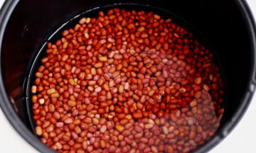 把浸泡好的红豆放入电饭煲中、加入适量清水
