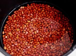 把浸泡好的红豆放入电饭煲中、加入适量清水