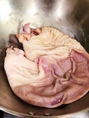 此时你会看到热锅把猪肚表面滑滑的粘液都吸在锅壁上了，将猪肚的两面往锅壁来回沾，然后取出，用清水冲洗。表面的粘液全部洗干净后。好快吧。