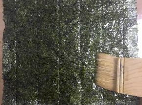 取一片海苔，在粗糙的面刷上酱料，刷满每个角落哦！