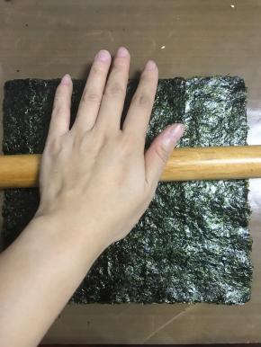 刷好酱料的海苔还在芝麻面上，用擀面杖擀压实点。