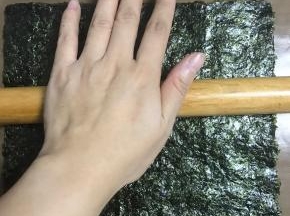 刷好酱料的海苔还在芝麻面上，用擀面杖擀压实点。